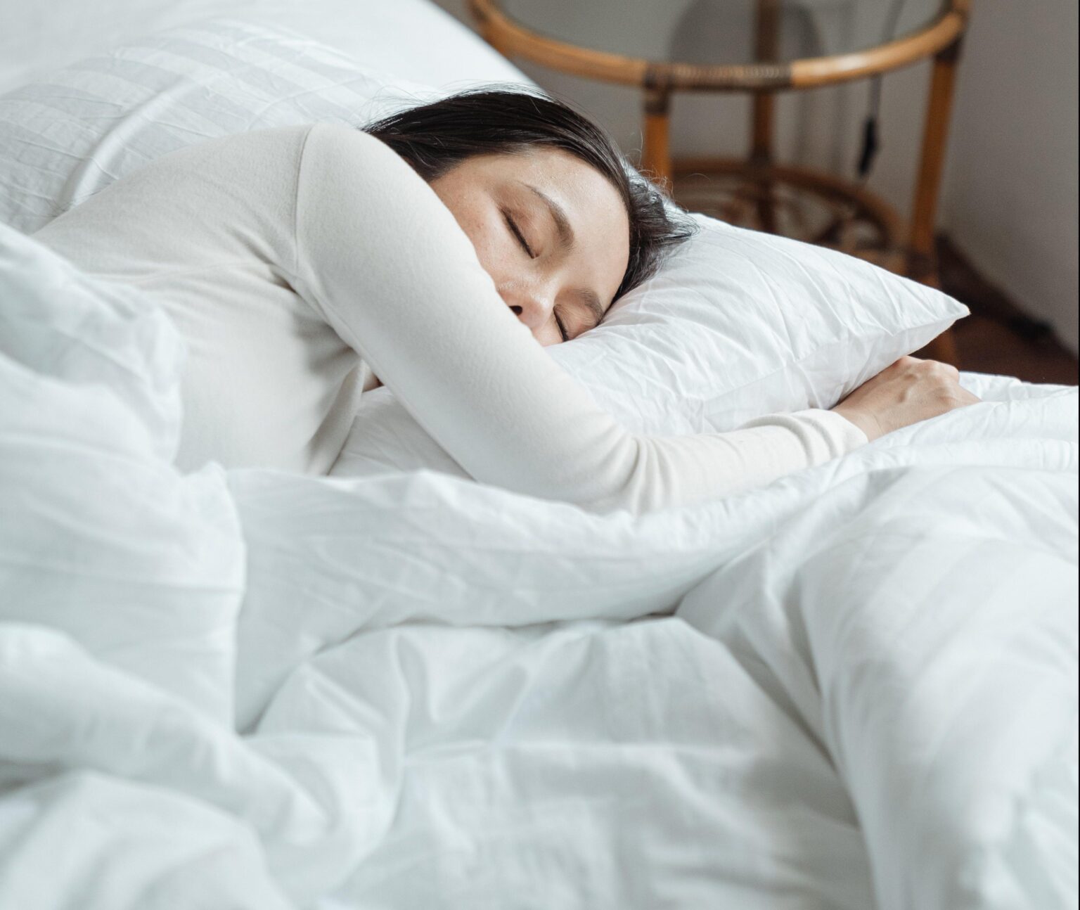 a woman sleeping in white sheets.