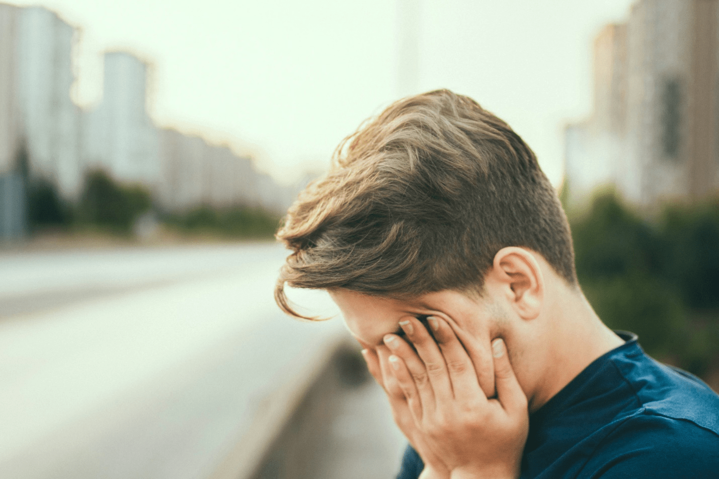 A tired person rubbing his eyes