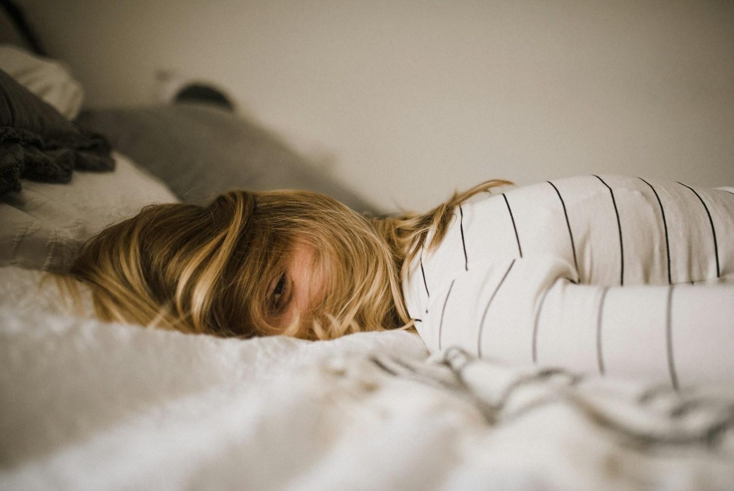 A woman in bed with one eye open