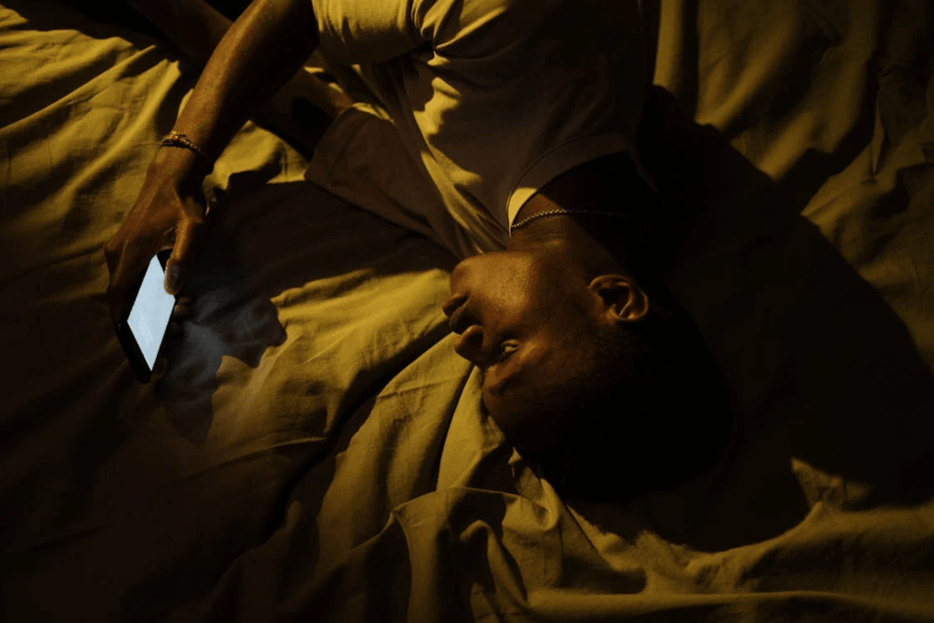 Man lying in bed using his phone