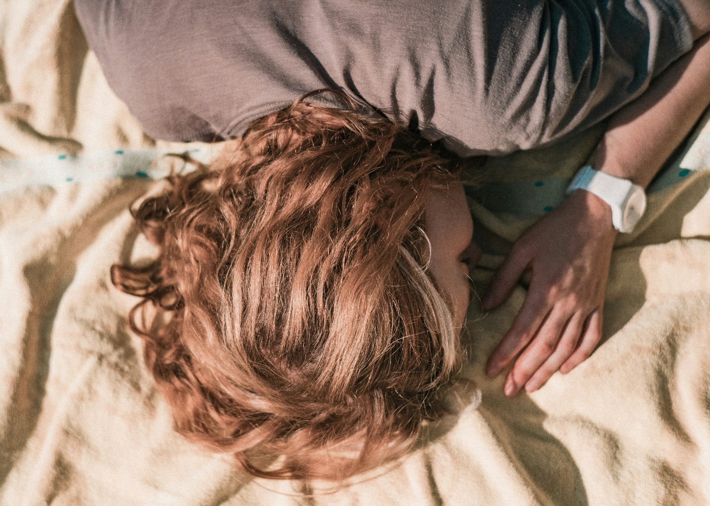 a woman sleeping with a watch on her hand. Actigrafo, Actigrafia