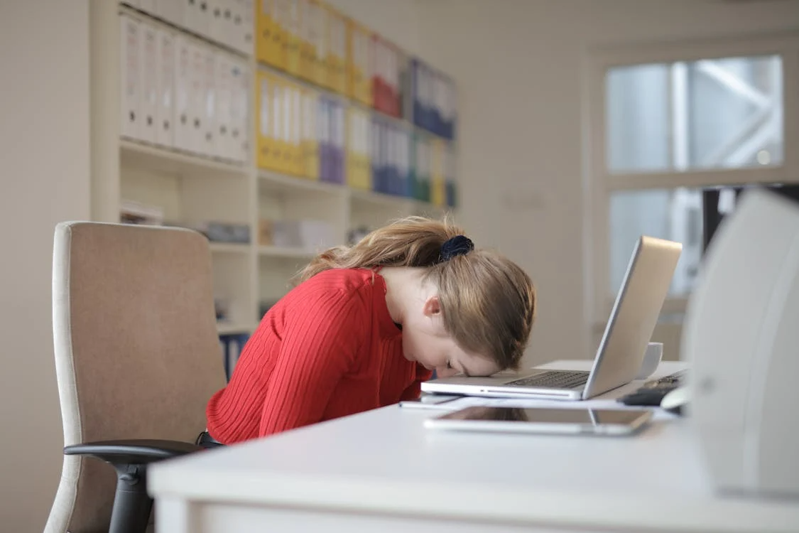 A woman sleeping at her desk