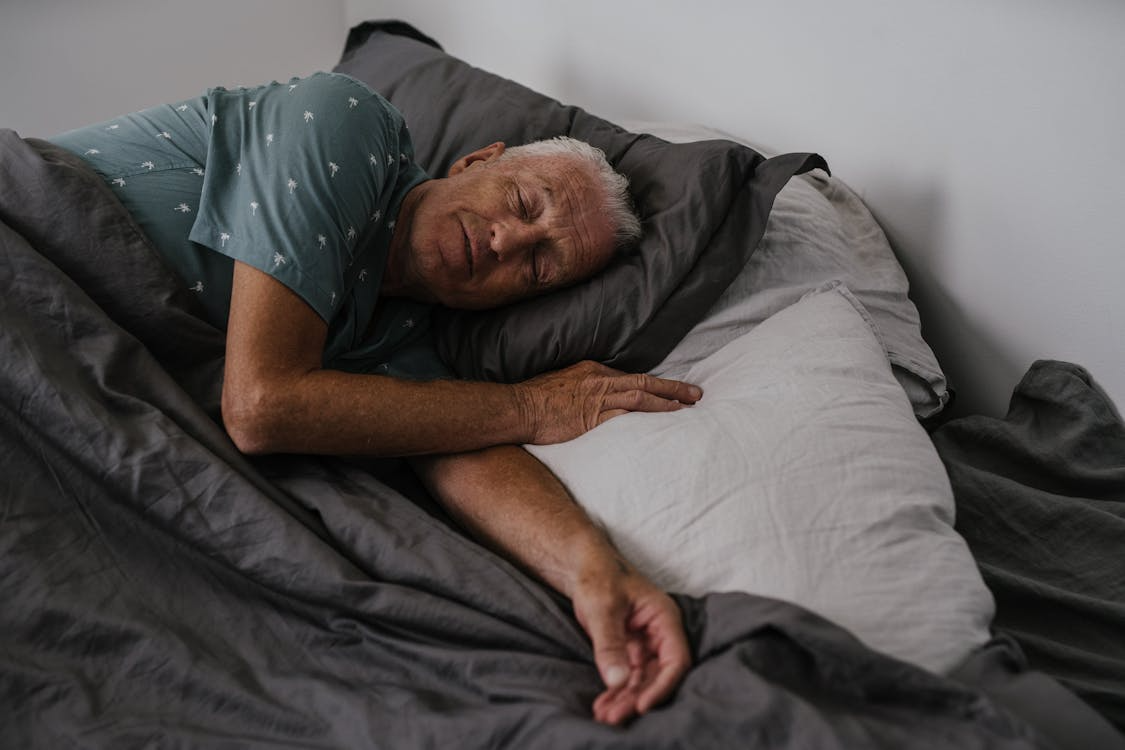 An elderly man sleeping in bed