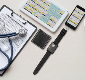 Wrist actigraphy device, stethoscope, patient medical history form, tablet, and phone displaying sleep data charts.