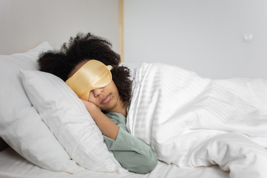 Individual wearing a sleep mask while resting in bed as part of a study investigating sleep quality and circadian light exposure.