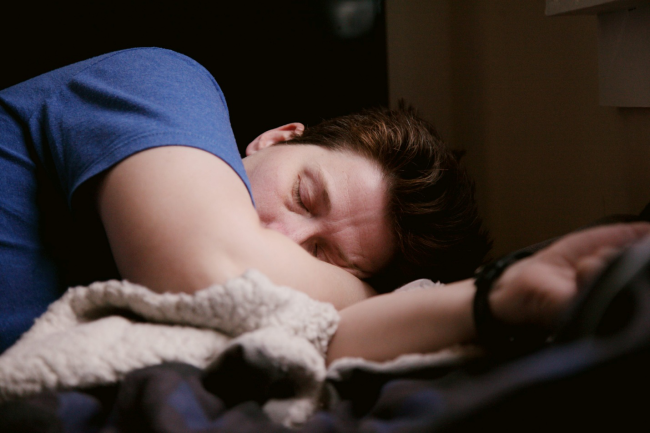 Person asleep wearing a wrist actigraphy device used for sleep and circadian rhythm research.